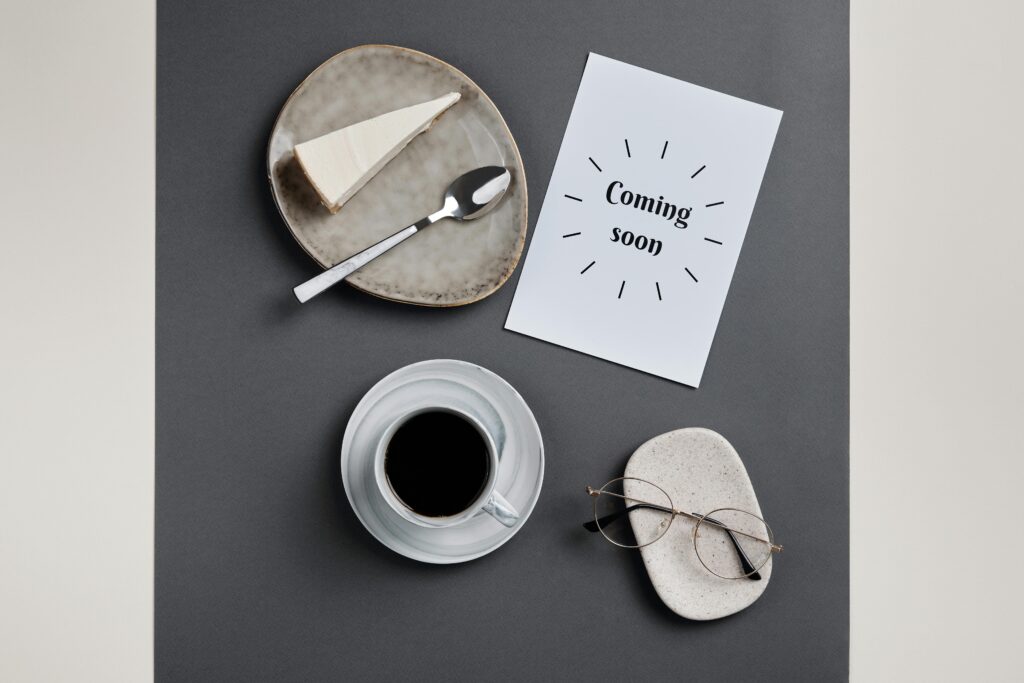 Stylish flatlay featuring coffee, slice of cheesecake, and eyeglasses on paper.